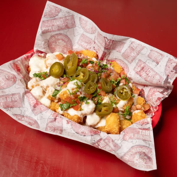 That Chicken Place's loaded tater tots with white sauce, pico de gallo, and jalapeños.